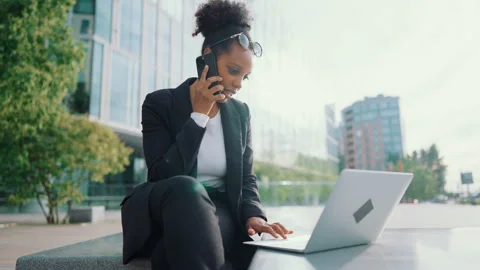 Multitasking woman freelancer or executive calling by phone from city street. Video stock 344390948