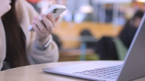 Multitasking woman using phone and laptop at cafe Stock Footage 341493937