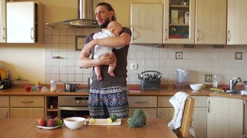 Multitasking young modern father. When mom is not at home. A man trying to cook Stock Footage 92525716