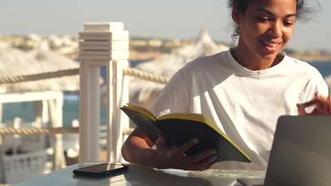 Multitasking. Young woman reading notes from her notebook during video Stock Footage 149436674