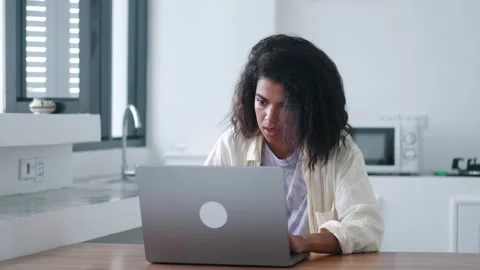 Multitasking young woman working remotely at laptop, performing urgent project Stock Footage 213258331
