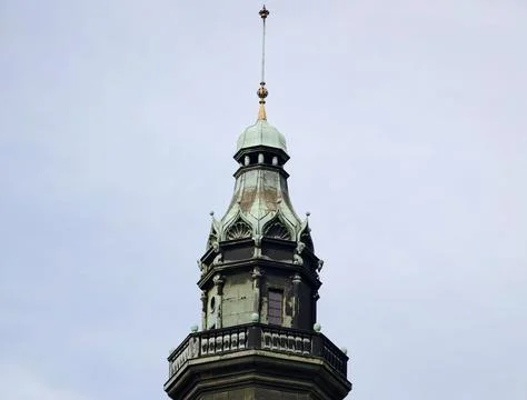 Multitiered structure featuring verdant copper dome set against moody cloud.. Stockfoto's