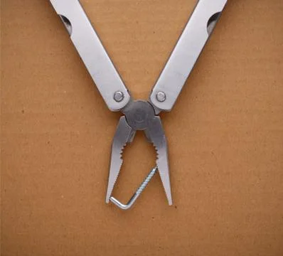 Multitool on cardboard. A tool for a variety of cases. Stock Photos
