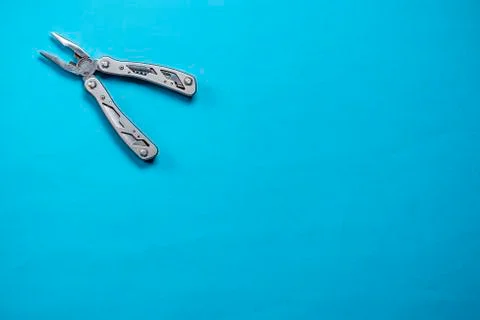 Multitool in the corner of the frame on a blue background Stock Photos