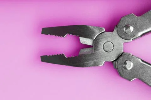 Multitool is a multi-functional tool on a pink background. The concept of an  Foto stock