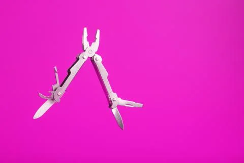 Multitool is a multi-functional tool on a pink background. The concept of an 库存照片