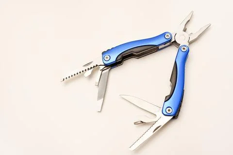 Multitool on a white background. Pocket multi-tool. Saw, knife and pliers. Stock Photos