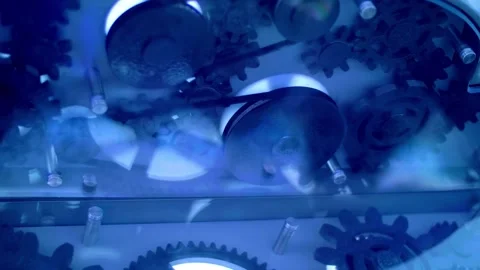 A multitude of black gears rotate under the glass Stock Footage 323942673