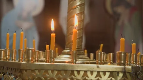 A multitude of flickering candles, bathed in warm, golden light, illuminate Vídeos de archivo 309665275