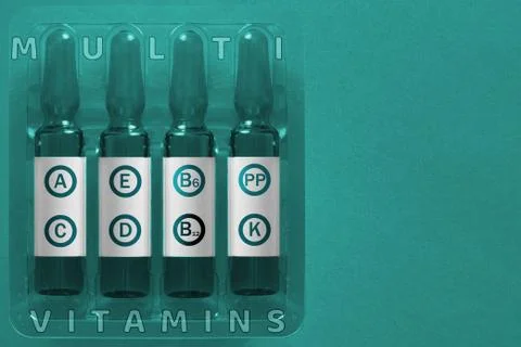 Multivitamins using concept. Four ampules with overlay letters of inscription 库存照片