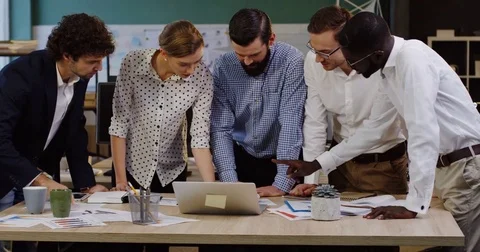 Multy ethnical office workers team leaning on a conference table with documents Stock Footage 82446129
