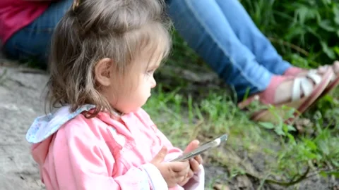 Mum and daughter sitting outside by the lake Stock Footage 131237299