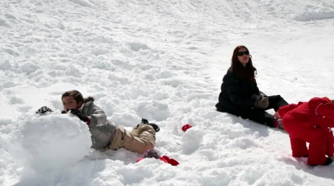 Mum and two children playing with snowballs Stock Footage 61876311