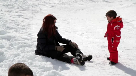 Mum and two children playing with snowballs Stock Footage 61876322