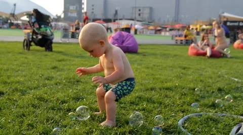Mum With the Child Blow Bubbles in the Park Stock Footage 64764346