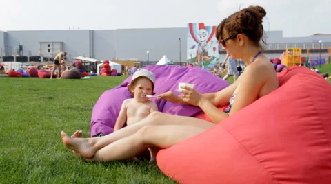 Mum Feeds the Child in the Park Video stock 64764177
