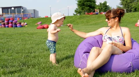 Mum Feeds the Child in the Park Stock Footage 64764230