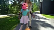 Mum Helps Her Little Daughter To Skate On Roller Skates Stock Footage