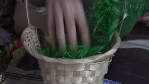 Mum preparing a basket of twigs with green grass for the Easter bunny to lay Stock Footage 166458612