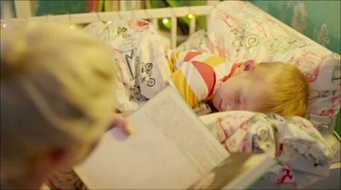 Mum reading bedtime book to her son Stock Footage 62732237
