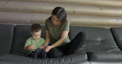 Mum is teaching her son to play developmental games for children on a digital Video stock 198581809