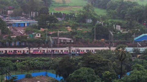 Mumbai local train moving in heavy monsoon rain green lush 4K Vídeos de archivo 345045940
