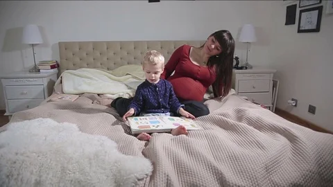 Mummy in pregnant is having fun with her toddler boy. FULL HD. tracking Stock Footage 73975367