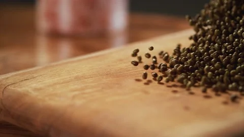 Mung beans are passing in front of the camera on the wooden floor. Stock Footage 140515581