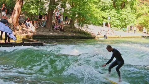 Munich, Germany - Jul 27, 2022: Surfer in the city river called Eisbach Vídeo Stock 211697245