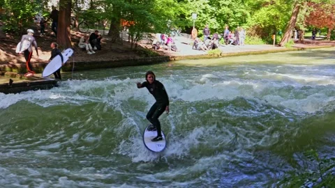 Munich, Germany - Jun 27, 2022: Surfer in the city river called Eisbach Stock Footage 201668385