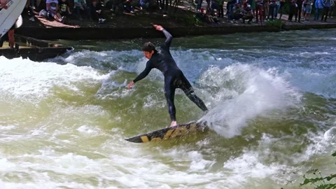 Munich, Germany - Jun 27, 2022: Surfer in the city river called Eisbach Stock Footage 201669366