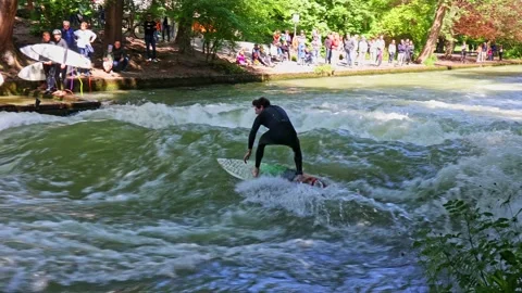 Munich, Germany - Jun 27, 2022: Surfer in the city river called Eisbach Stock Footage 201669487