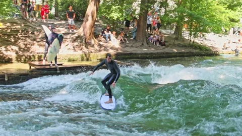 Munich, Germany - Jun 27, 2022: Surfer in the city river called Eisbach Stock Footage 201669842