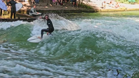 Munich, Germany - Jun 27, 2022: Surfer in the city river called Eisbach Stock Footage 202983467