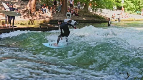 Munich, Germany - Jun 27, 2022: Surfer in the city river called Eisbach Stock Footage 202984318