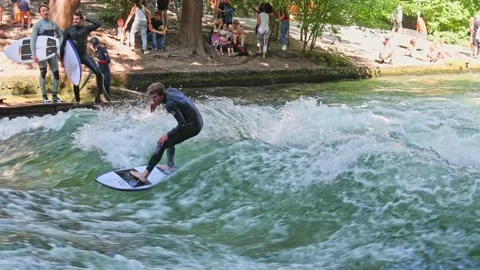 Munich, Germany - Jun 27, 2022: Surfer in the city river called Eisbach Stock Footage 206332957