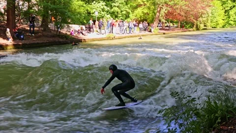 Munich, Germany - Jun 27, 2022: Surfer in the city river called Eisbach Stock Footage 206338596