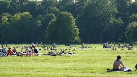 Munich, Germany - June 2018: People relaxing in the park on green grass Stock Footage