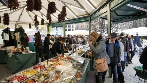 MUNICH, GERMANY - MARCH 10, 2018: People buying food at an outdoor market Stock Footage 95405076