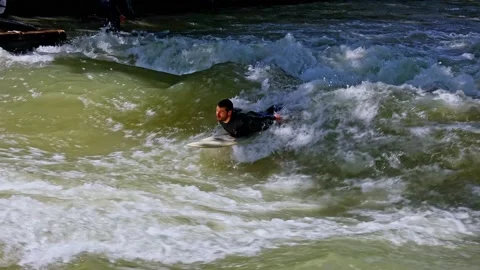 Munich, Germany - May 27, 2022: Surfer in the city river called Eisbach Stock Footage 201157843