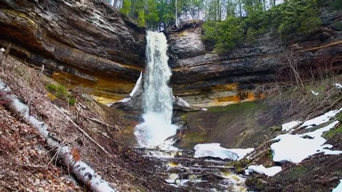 Munising Falls cascading down rock cliffs surrounded by forest at Pictured Rocks Stock Footage 308958542