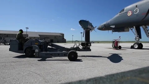 Munitions airman driving bomb loader with ordnance towards B2 Lancer Stock Footage 112124989