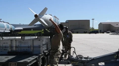 Munitions airman removing bomb from trailer with loader Stock Footage 112125053
