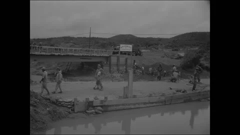 MUNSAN-NI - 1953 - A group of engineers works on an old bridge over a ravine Stock Footage 337709947