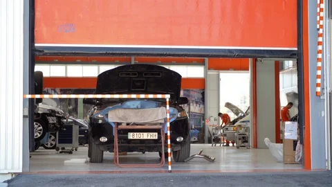 Murcia, Spain - October 24, 2017 - Wide Shot Of Car Garage With People Working Stock Footage 129443992