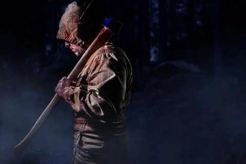 Murderer with an axe in dark woods. Stock Photos