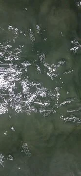 Murky Gray Water Surface with Bright Sunlight Reflections and Gentle Ripples 写真素材