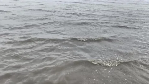 Murky sea waves ripple across the water under an overcast sky Stock Footage 340130607