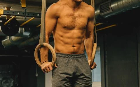 Muscle up exercise athletic man doing intense workout at the gym on gymnastic Foto stock