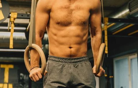 Muscle up exercise athletic man doing intense workout at the gym on gymnastic Stock Photos